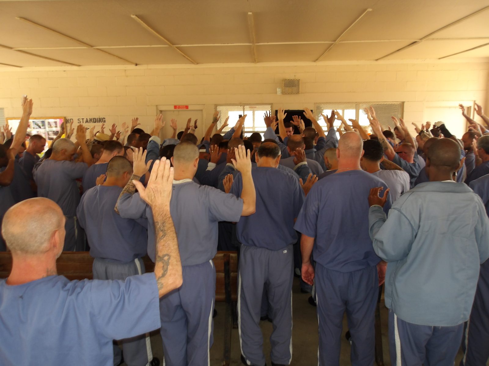 Inmates raising their hands in worship during the crusade