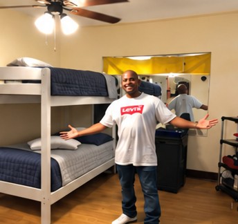 James with arms open in his new room